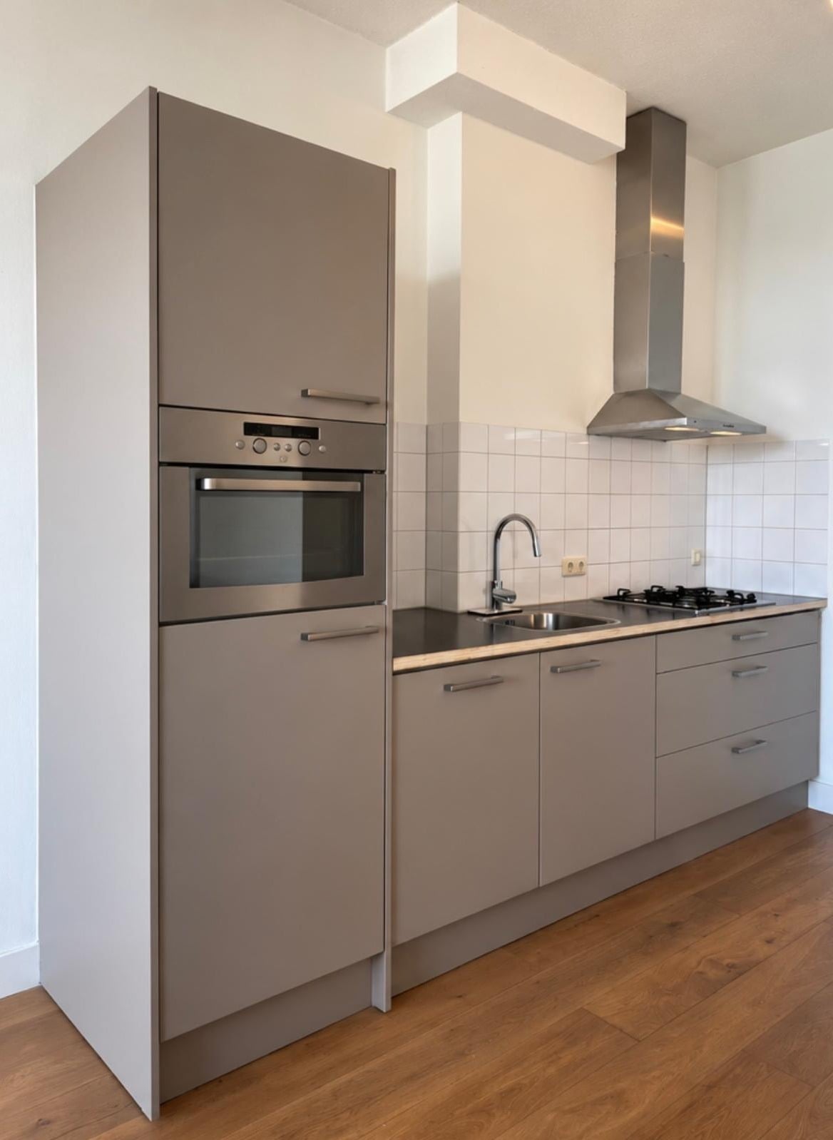 Dezelfde keuken na het wrappen, met matte taupe fronten